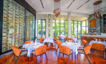 The restaurant features large windows and tables adorned with tablecloths in its dining area at Hotel Vellita Siem Reap