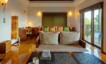 a spacious living room with a couch , dining table , and sliding glass doors leading to an outdoor area at Sankara Hotel & Spa Yakushima