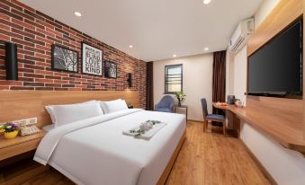 The bedroom features a modern double bed with a large flat-screen television mounted on the wall at Maker Hotel