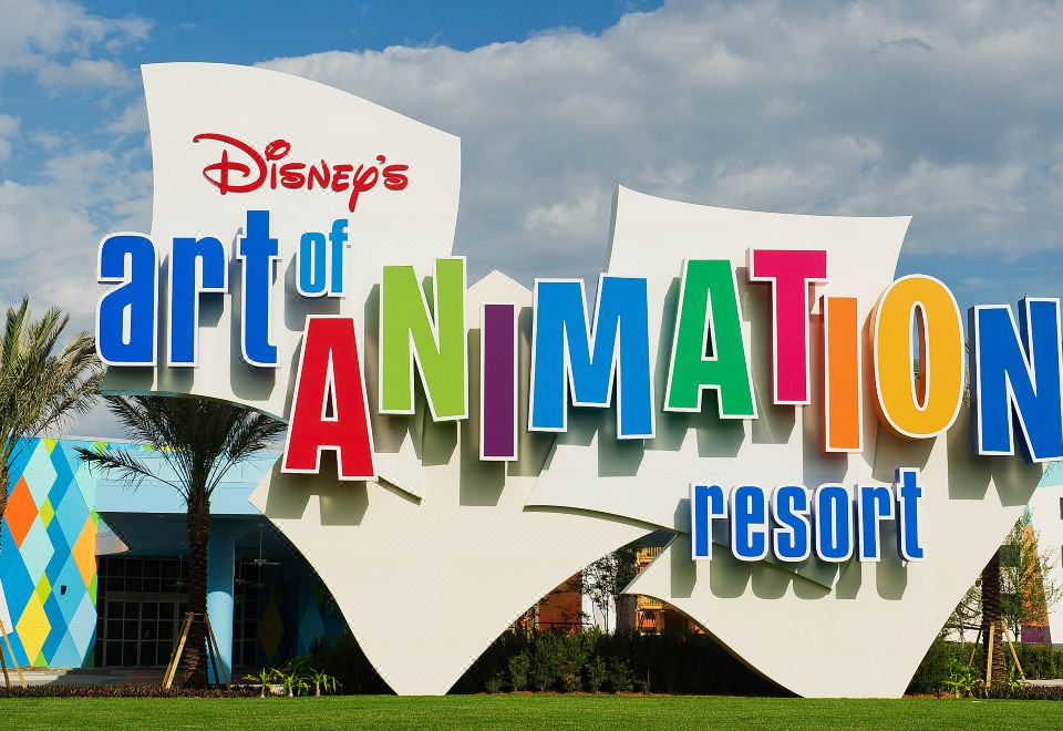 the exterior of disney 's art of animation resort , with the hotel 's name displayed in large letters at Disney's Art of Animation Resort