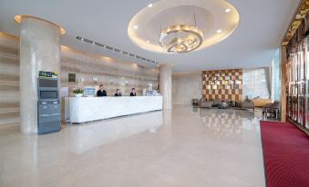 The hotel features a spacious lobby adorned with marble floors and a wood-paneled ceiling, complemented by a reception desk at Gems Cube International Hotel