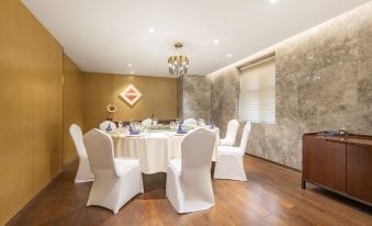 A room is set up with tables and chairs for an event at a hotel or another venue at Jinfan Wanyuan Hotel