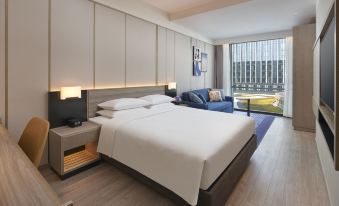 The modern bedroom features large windows, a white bed, and a wood-paneled accent wall at Hyatt Place Hangzhou International Airport