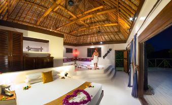 a man standing in a bedroom with a woman standing in the middle of it at Navutu Stars Resort
