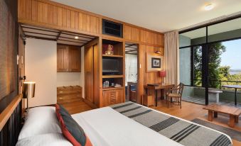 a modern hotel room with wooden paneling , a bed , and a balcony overlooking the city at Heritance Kandalama