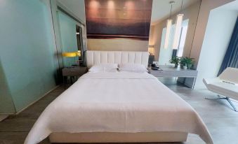 There is a bed with white sheets and pillows in the middle, next to an empty headboard at Metropolo Jinjiang Hotels (Hangzhou East Railway Station)