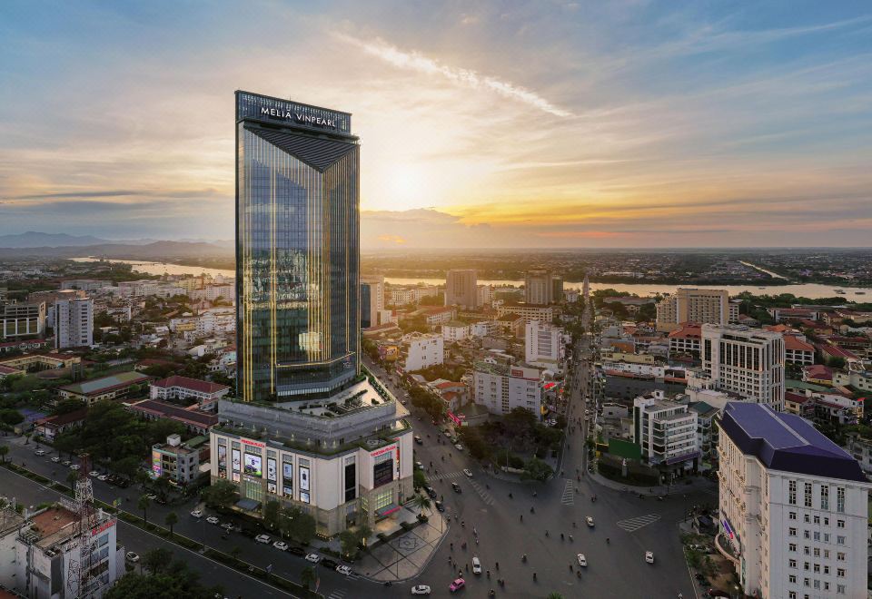 a modern cityscape with a large glass building in the center and other buildings surrounding it at Melia Vinpearl Hue
