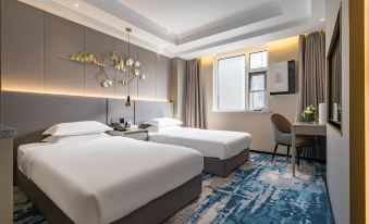 The bedroom features double beds and a large doorway with windows that lead to another area at VOYAGE INTERNATIONAL HOTEL