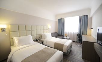 The bedroom features a double bed, a large window, and a table in the center at Panda Hotel