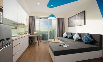 a modern living room with a large window and blue ceiling , featuring a couch and dining table at TUI BLUE Nha Trang