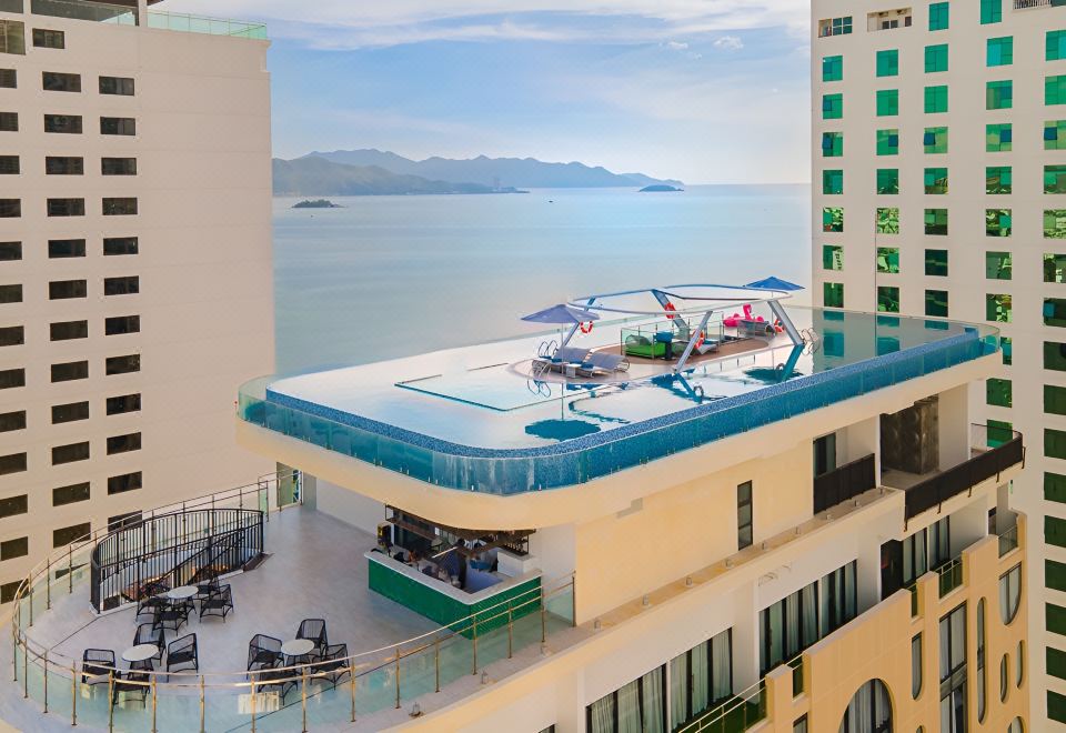 The hotel features a spacious swimming pool with a stunning ocean view, and the roof is adorned with a blue water design at Grand Tourane Nha Trang Hotel