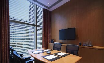 The conference room features large windows, a wooden table, and chairs, all positioned towards the television at Hyatt Regency Hong Kong, Tsim Sha Tsui