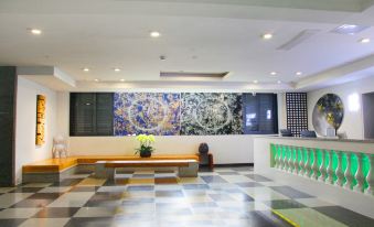 The lobby, adorned with large windows and wall paintings, alongside an art gallery, provides a welcoming and visually pleasing ambiance for guests at Timmy Apartment Hotel