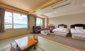 a modern living room with large windows , wooden furniture , and a view of the sea at Fuji Matsuzono Hotel