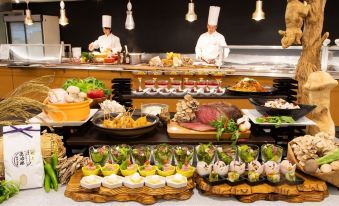 a buffet table with a variety of food items , including meat , vegetables , and desserts , as well as chefs preparing food in the background at Naeba Prince Hotel