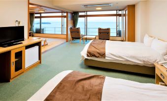 a hotel room with two beds , one on the left side of the room and the other on the right side at Hotel Urashima
