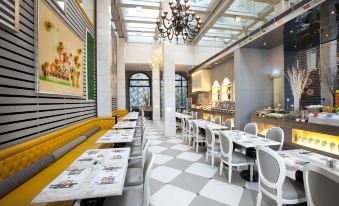 The restaurant has white tables and chairs, with tiled floors in the center, creating an open space at Dorsett Shanghai