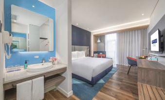 A modern bedroom with a double bed and a large bathroom is located on the other side at Holiday Inn Express Shanghai Gubei