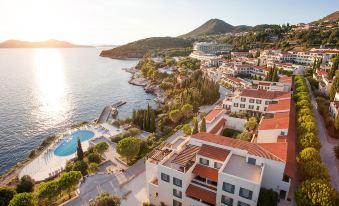 a bird 's eye view of a resort with multiple buildings and a pool overlooking the water at Sun Gardens Dubrovnik