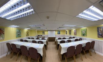 A spacious conference or meeting room is arranged with tables and chairs for an event at Best Western Plus Hotel Kowloon