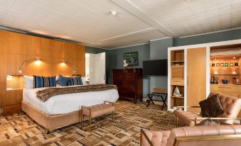 a spacious hotel room with a large bed , wooden furniture , and a television mounted on the wall at Islington Hotel