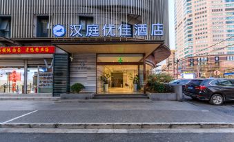 The front entrance of a hotel in an oriental city is adorned with large signs above it at Hanting Youjia Hotel (Shanghai East Nanjing Road Branch)