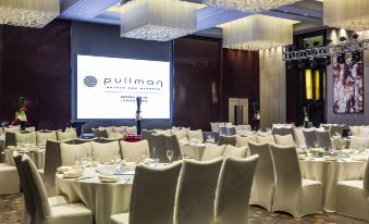 A ballroom is arranged for an event, with tables and chairs placed in the center at Pullman Shanghai Jing An