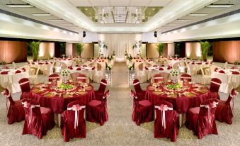 A ballroom is arranged for an event, with tables and chairs placed in the center at Regal Riverside Hotel