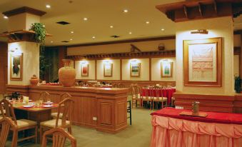 a large dining room with wooden tables , chairs , and a bar , decorated with paintings on the walls at Rimpao Hotel
