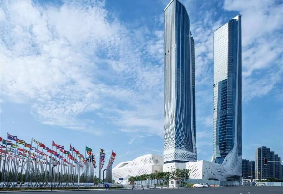 The city's skyline, featuring tall buildings against a backdrop of a blue sky, including one resembling a sail, provides an ideal location for an opulent hotel at International Youth Convention Hotel (Nanjing International Youth Cultural Centre)