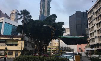 The cityscape features tall buildings and trees in the foreground, creating an urban setting at Izumi Hotel Bukit Bintang Kuala Lumpur