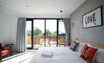 a spacious bedroom with a large bed and a sliding glass door that leads to a patio area at Red House
