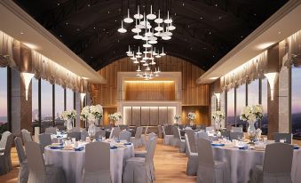 a large , well - lit banquet hall with numerous dining tables and chairs arranged for a formal event at Rattanachol Hotel