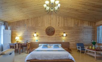 a spacious wooden bedroom with walls and ceiling covered in wood paneling, featuring a bed beside it at Zhenmei Resort Chain Hotel(Yangshuo West Street AiYuan Store)