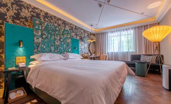 A bedroom with a large bed and a chair next to the window at Jinjiang Metropolo Shanghai Xintiandi Hotel