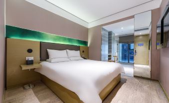 A modern bedroom with a large bed and white furnishings in the corner during dusk at Hanting Youjia Hotel (Shanghai East Nanjing Road Branch)