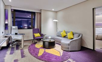 elegant and spacious space, featuring large windows, a comfortable couch, and a chair in the center at Hampton by Hilton Shenzhen North Station