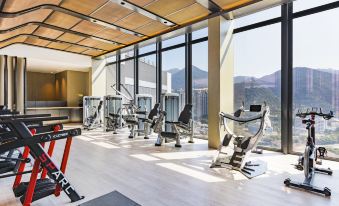 The modern gym features large windows and floor-to-ceiling glass in the center at Alva Hotel by Royal