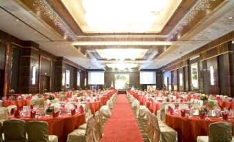 A ballroom is arranged for an event, with tables and chairs placed in the center at Hotel Fortuna