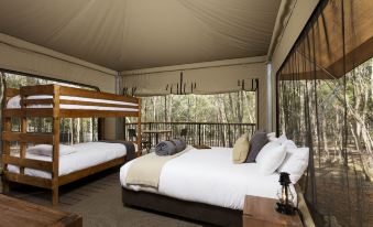 a large bed with a wooden headboard and footboard is situated in a room with a tipi - like ceiling at Paradise Country Farmstay