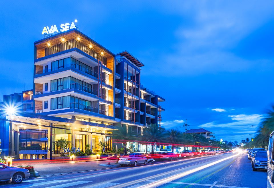 "a modern hotel building with the name "" at sea "" lit up on the side , situated near a busy street" at AVA SEA Resort Krabi