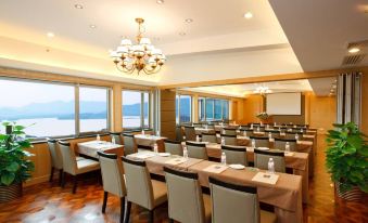 The restaurant features large windows and tables arranged for business meetings, providing a dining experience with a view at Merchant Marco Hotel