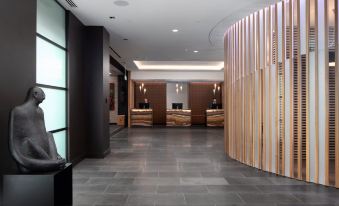 a hotel lobby with a reception desk and a hallway leading to the bathroom area at Rydges Wellington Airport, an EVT hotel