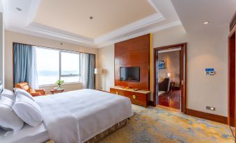 The middle room of this hotel features a large bed, windows, and a balcony that overlook other rooms at Glory Charm Hotel