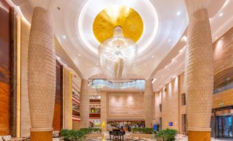The large building features a lobby and main entrance adorned with chandeliers on each side at Glory Charm Hotel