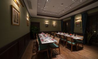 A table set for four is placed in the middle room, featuring large windows and wood paneling at Huaihai Mansion