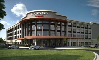 "a large building with the name "" courtyard marriott "" prominently displayed on its front , surrounded by trees and grass" at Courtyard Austin Pflugerville and Pflugerville Conference Center