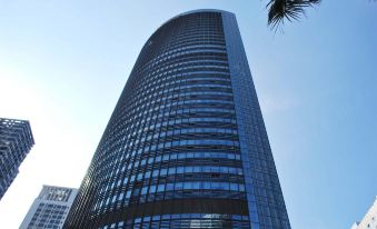 In front of an office tower, there is a tall building with many windows on its side at Shenzhen Huaqiang Plaza hotel (Huaqiangbei Metro Station)