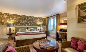 a hotel room with a large bed , a desk , and a window overlooking a lake at Grosvenor Pulford Hotel & Spa