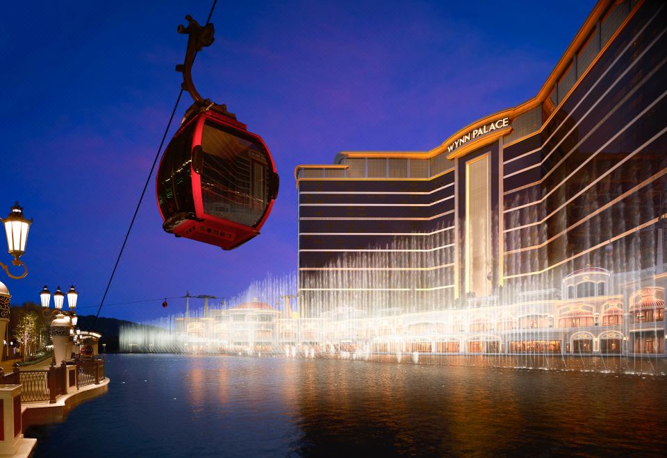 A large illuminated building surrounded by water in the center at Wynn Palace